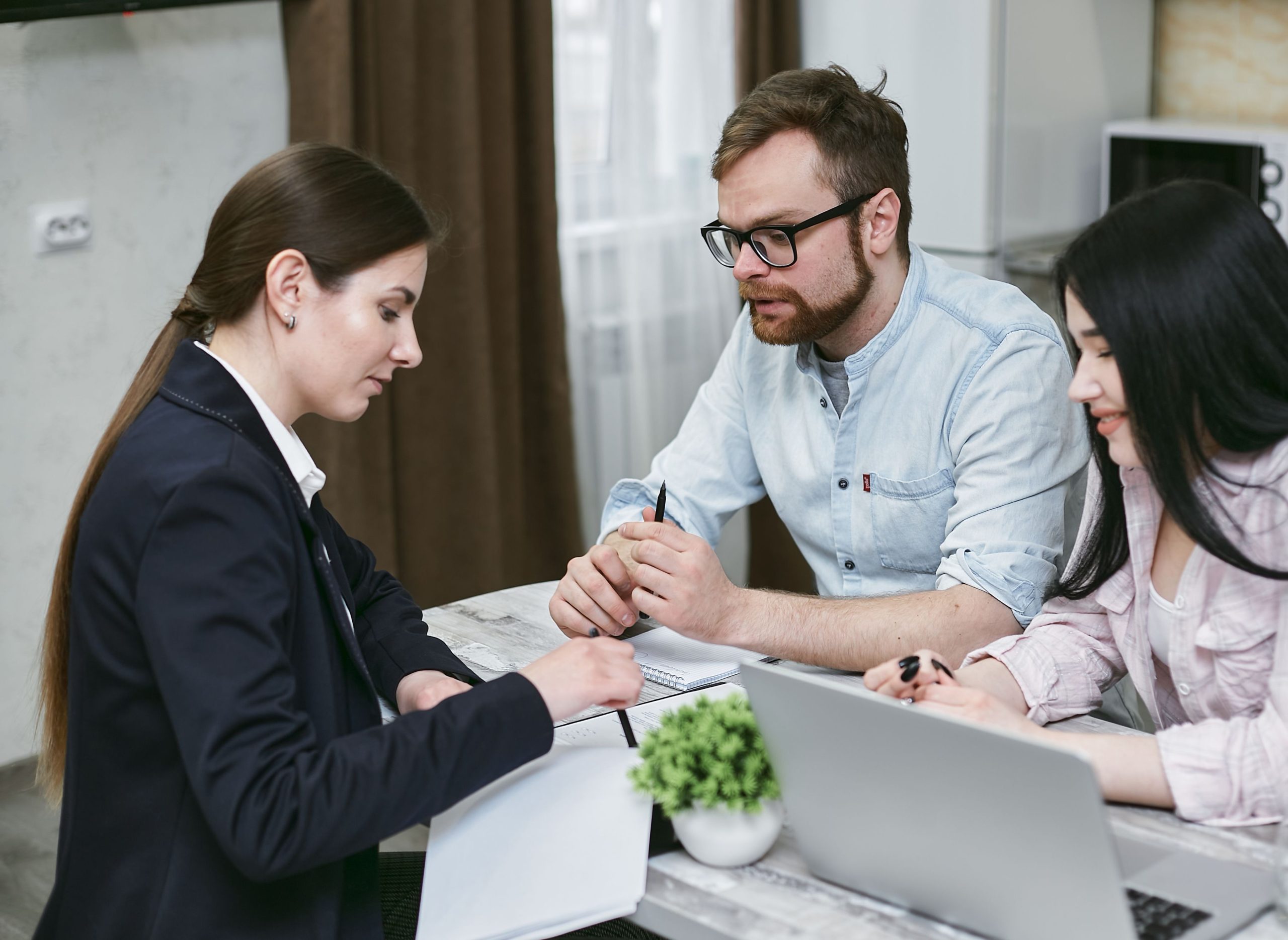 Home A couple discusses financial documents with their advisor, highlighting investment strategies.